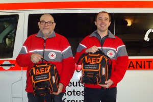Die First-Responder Norbert Bach und Christoph Becker haben die neuen AED-Geräte erhalten. Foto: Guido Schultes, DRK Rhens 